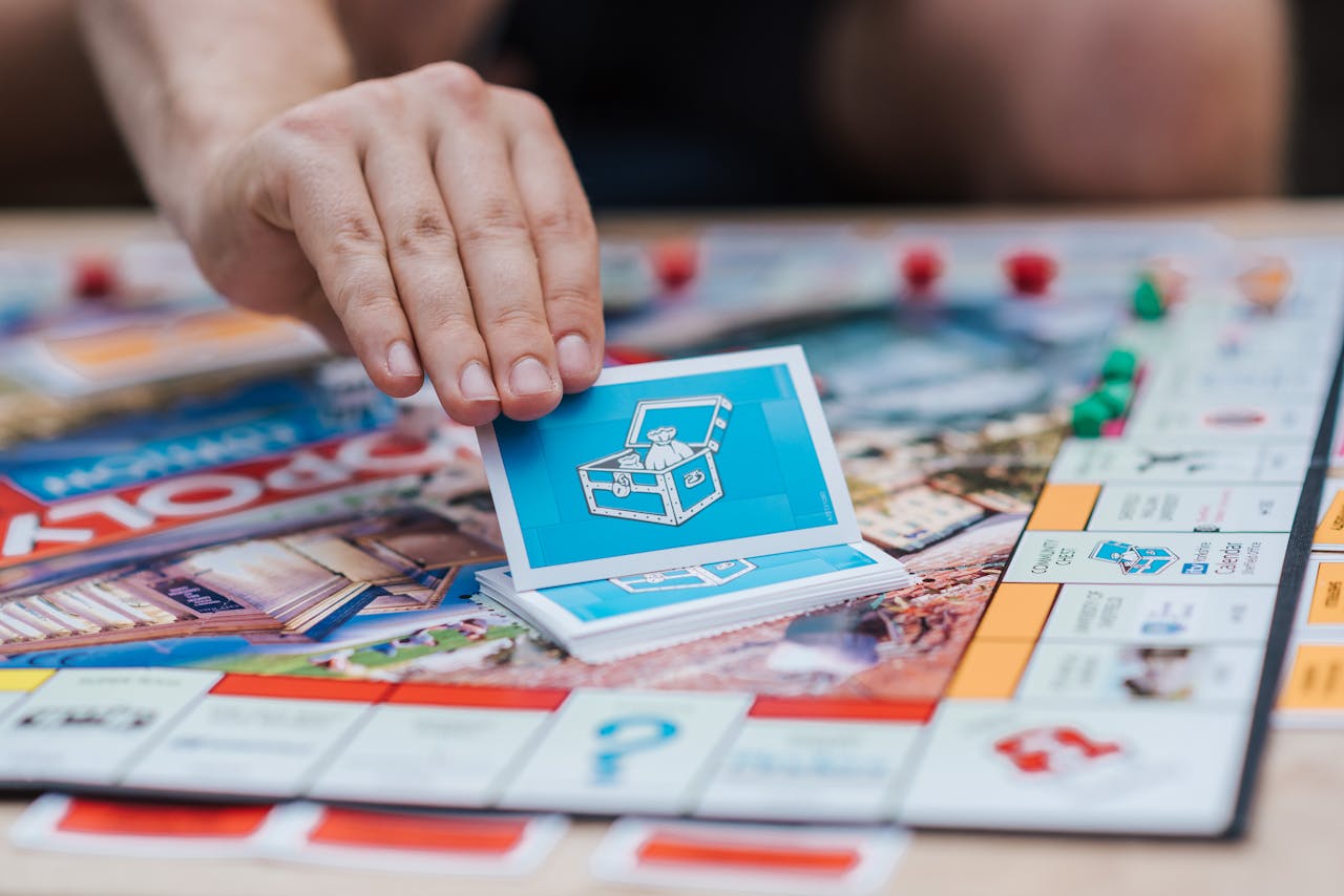 A close-up shot of a hand picking a card during a Monopoly board game session.